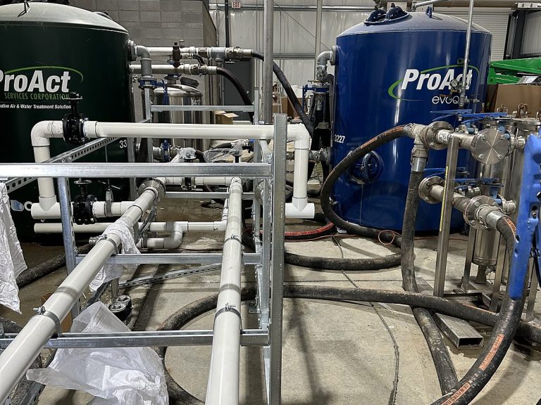 Commercial water treatment tanks with white PVC manifold piping