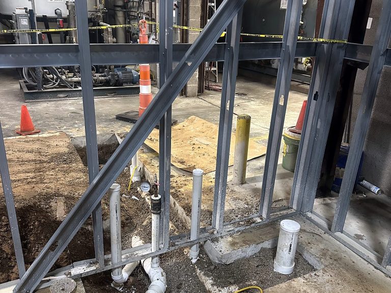 Plumbing rough-in under steel framing before a concrete pour