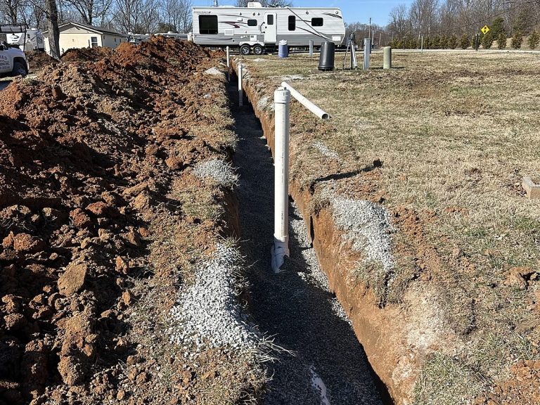 Long open trench with a water line across a yard
