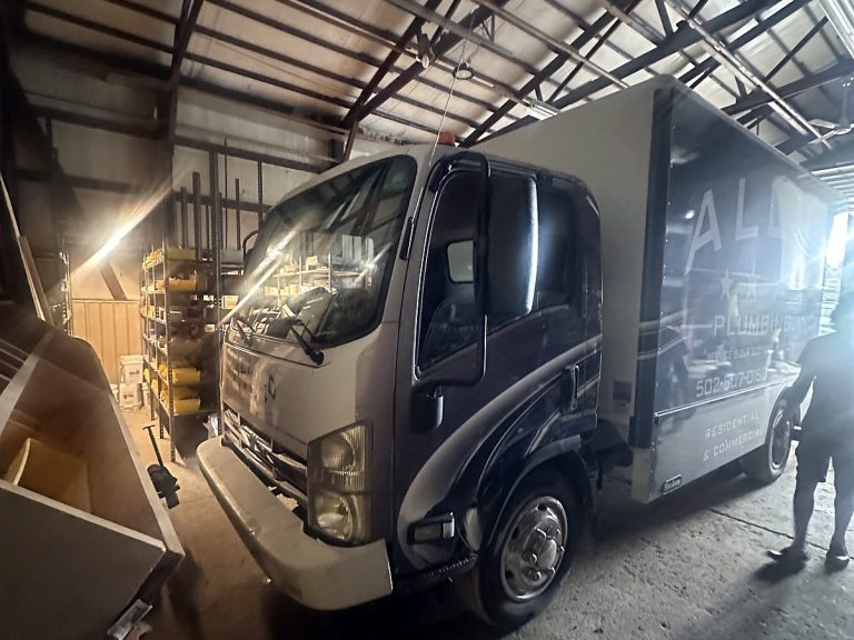Allied Plumbing box truck inside a barn workshop