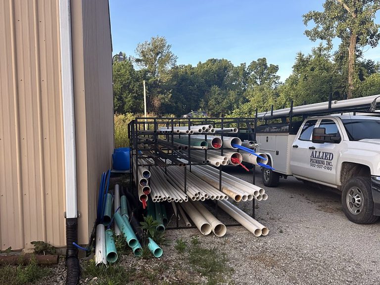 Pipe rack and service trucks outside the Allied Plumbing shop