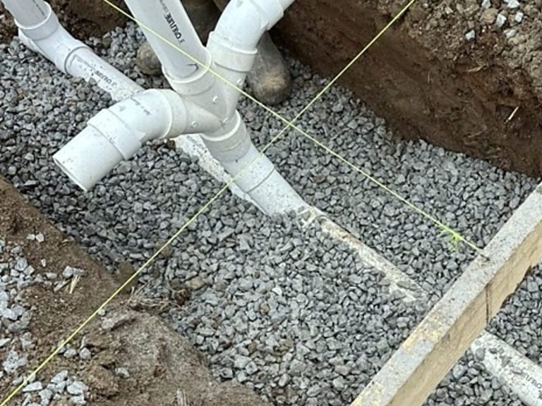 PVC drain fitting bedded in gravel under a slab