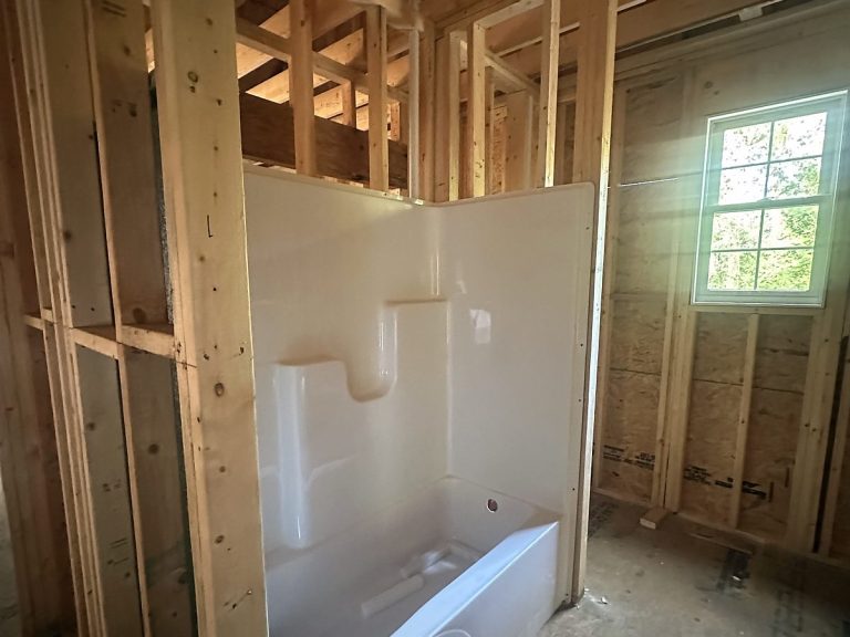 Bathtub in a framed bathroom before drywall
