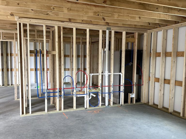 Plumbing rough-in throughout a framed house interior