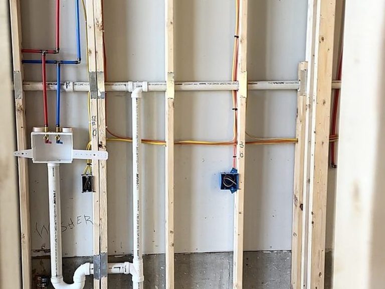 Plumbing rough-in in a framed bathroom wall