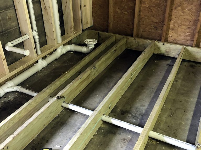 PVC drain lines running through floor joists