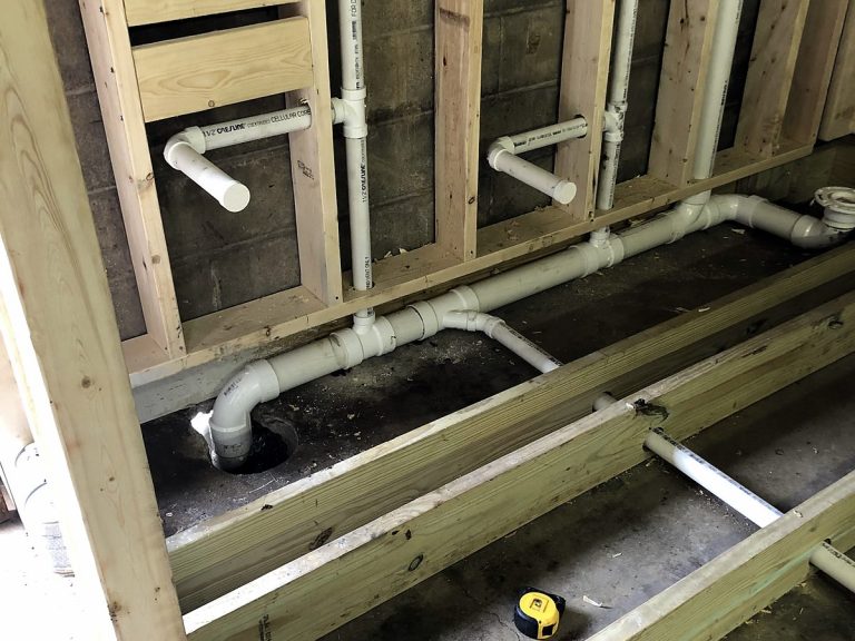 PVC drain and vent piping between floor joists