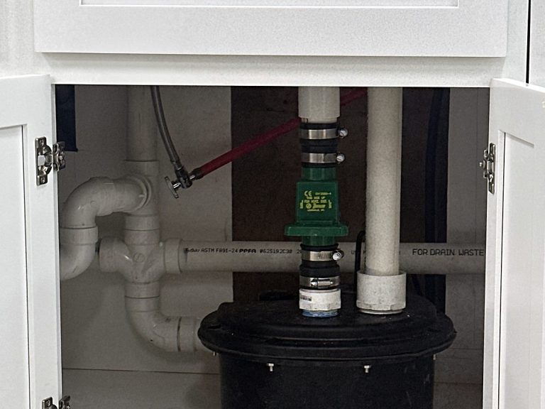 Garbage disposal and drain piping under a kitchen sink