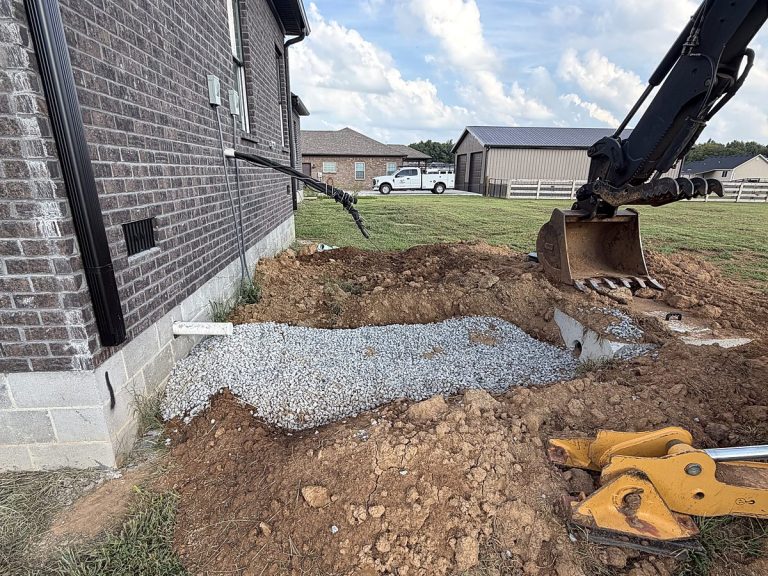 Excavator digging beside a brick house