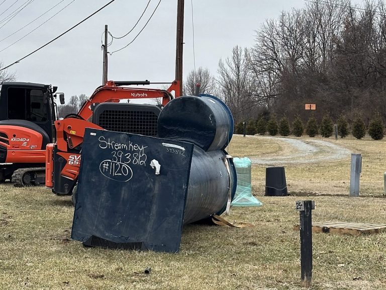 Septic tank on the ground at a job site with equipment