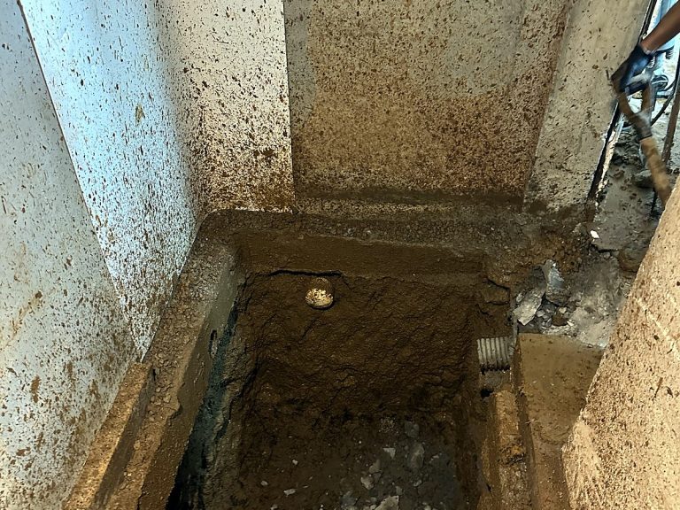 Excavated pit through a concrete floor