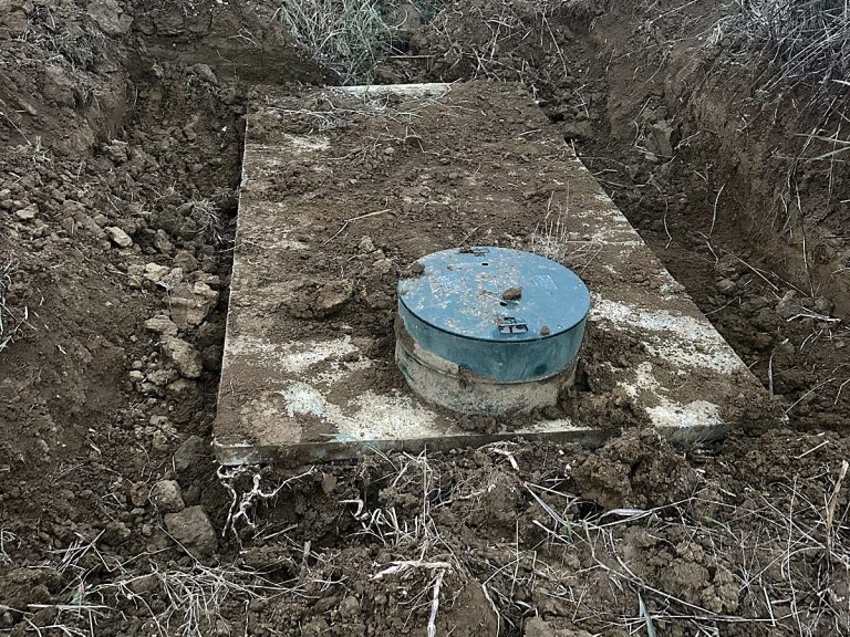 Green septic riser lid in a backfilled yard