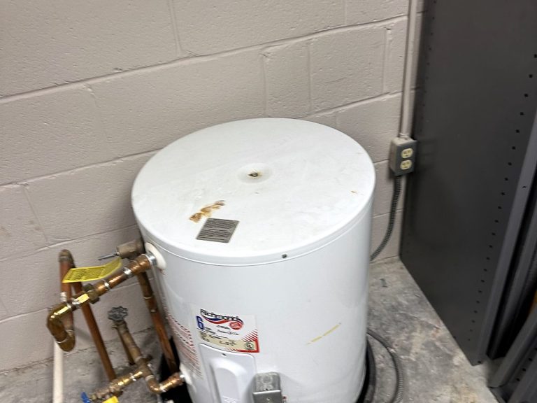 Small white electric water heater on a floor