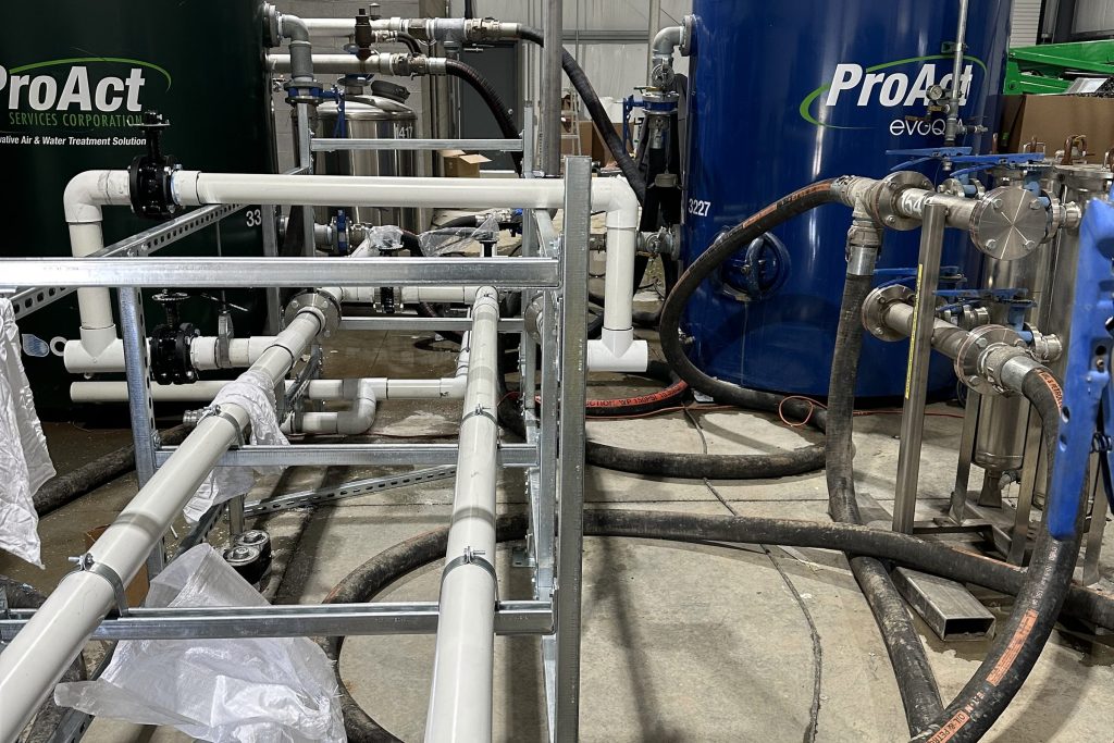 Commercial water treatment tanks and manifold piping in a pump room