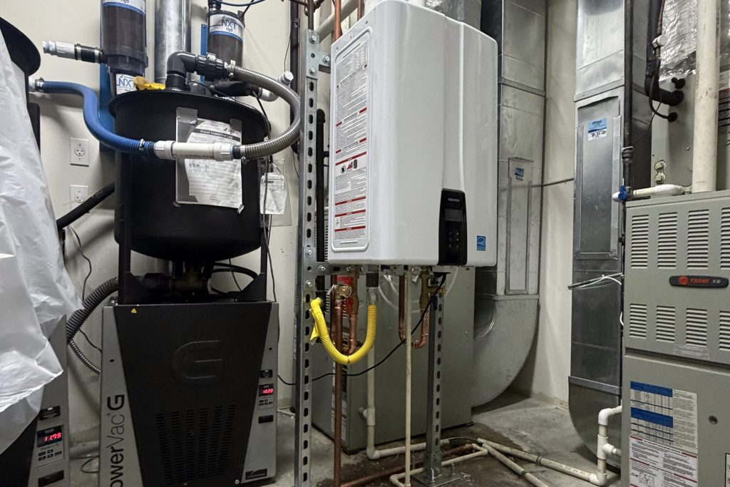 Tankless water heater and water softener side by side in a utility room