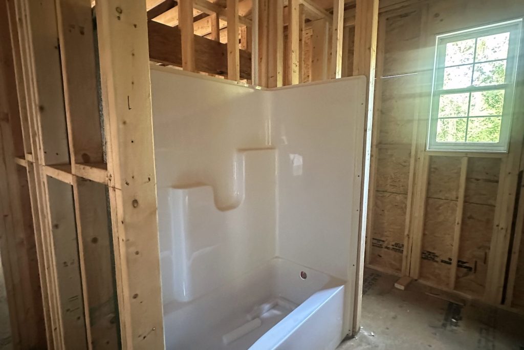Bathtub in a framed bathroom before drywall